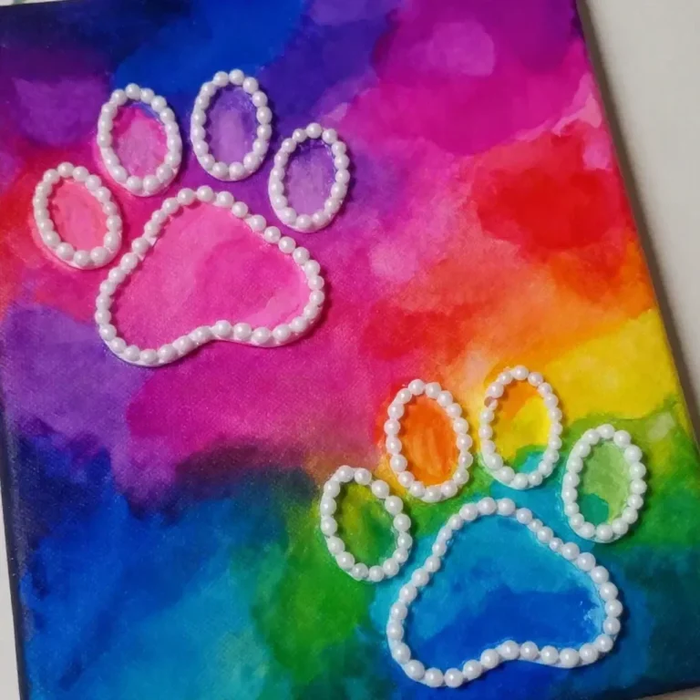 Colorful salt painting of a rainbow puppy paw created by kids